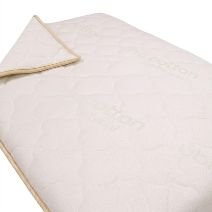 Light beige quilted coverlet on a white background