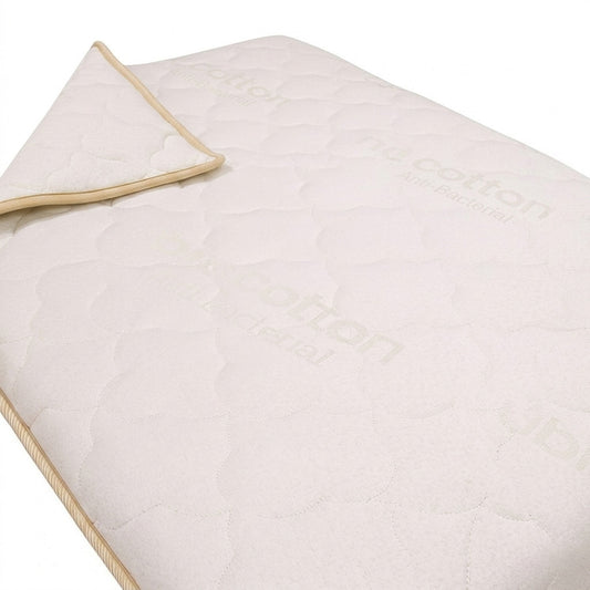 Light beige quilted coverlet on a white background