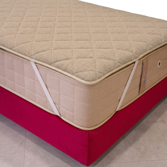 Beige mattress with quilted top on a red platform against a neutral background